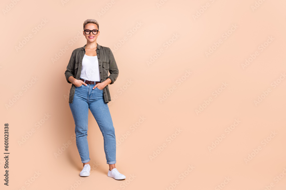 Full size portrait of cheerful stunning lady economist put hands pockets empty space isolated on beige color background