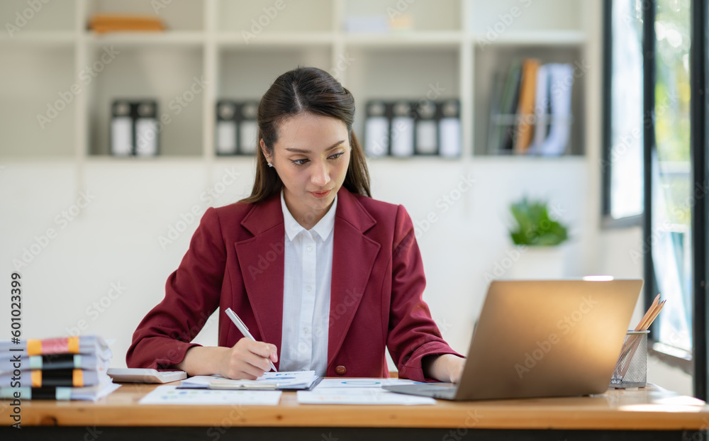 Asian businesswoman clicking details on laptop computer analyzing data checking accuracy of financial income happily in office management concept management. Asian businesswoman clicking details on laptop computer analyzing data checking accuracy of financial income happily in office management concept management.