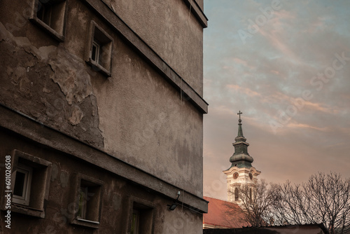 Panorama of the catholic church in Kovin, the rimokatilicka crkva svete terezije avilske, with an old decaying building in front. Kovin is a Serbian city in the rural province of Vojvodina. photo