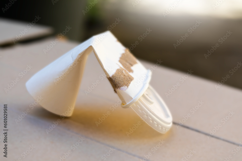 Disposable crumpled drink paper cup on blurred wooden background. Environmentally friendly concepts. Disposable crumpled drink paper cup on blurred wooden background. Environmentally friendly concepts.