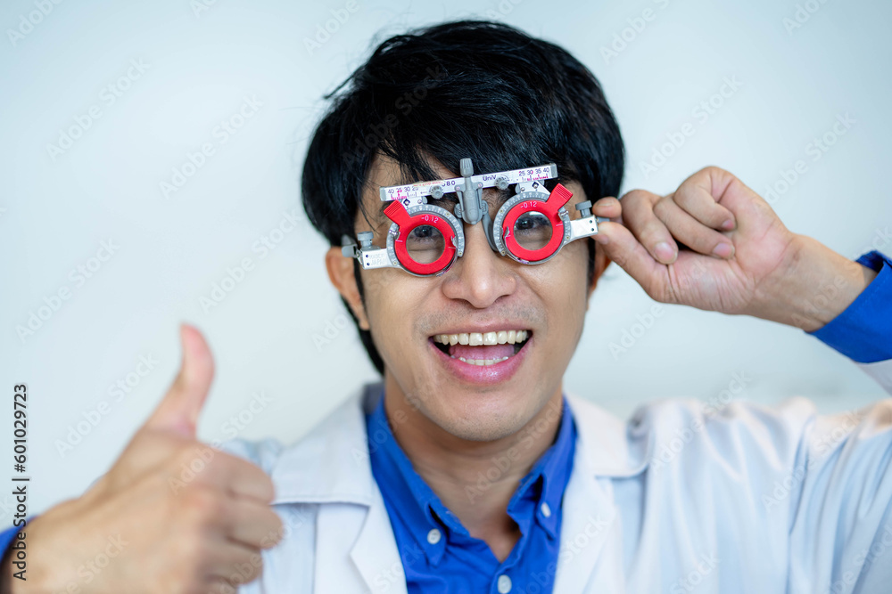 Happy man checking vision with eye test glasses during a medical examination at the ophthalmological office, Checking eye vision by optician health examination concept Happy man checking vision with eye test glasses during a medical examination at the ophthalmological office, Checking eye vision by optician health examination concept