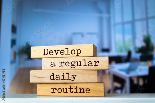 Wooden blocks with words 'Develop a regular daily routine'.