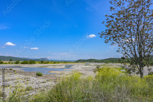 Dried up riverbed of the Pinios near Kalambaka in Thessaly  Greece  low water after heat and drought  potential effect of global climate warming  wide landscape under a blue sky  copy space