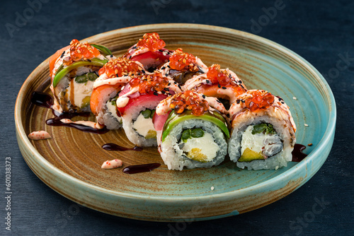 Sushi rolls with tuna, salmon, eel, cream cheese, avocado, red caviar and sauce.