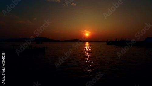 Timelapse of the dreamy summer sunrise over the busy fishing port in Koh Sdach Island in Cambodia showing the genuine local daily life photo