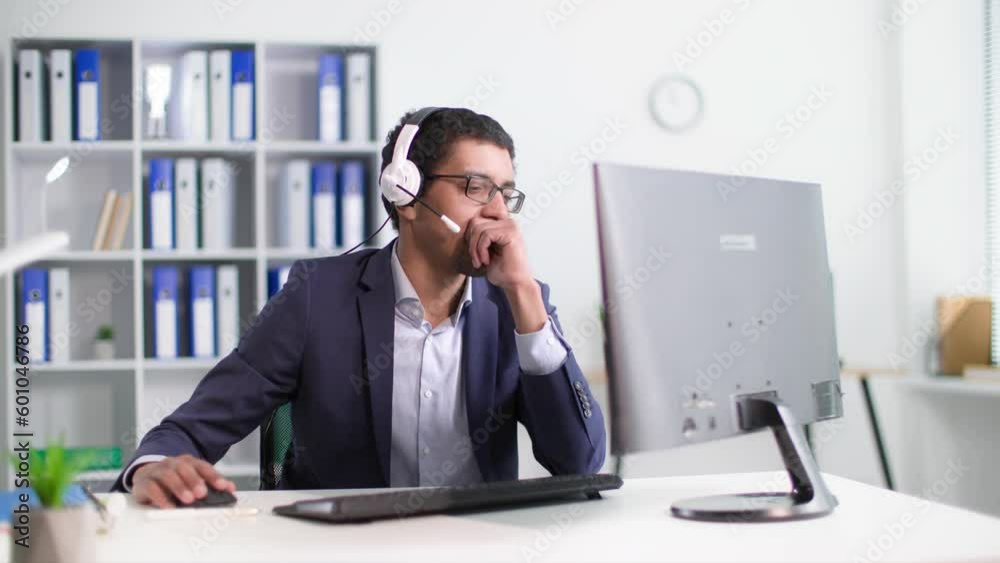 call center operator, young black man consulting a client using a headset while sitting at computer in office call center operator, young black man consulting a client using a headset while sitting at computer in office