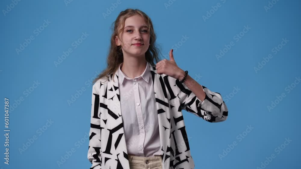 4k video of one girl showing thumb up over blue background. 4k video of one girl showing thumb up over blue background.