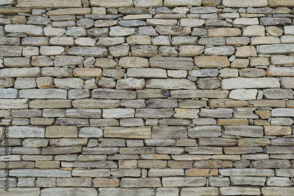 The texture of the wall laid out of layered stone. Natural background.