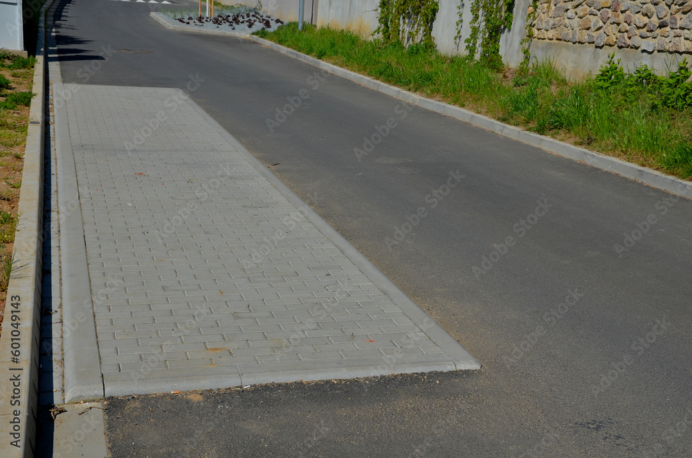 in the middle of the road leading to the residential area, the police and the traffic office installed a red plastic retarder. raised square made of rubber beveled on the sides, arrow, triagle