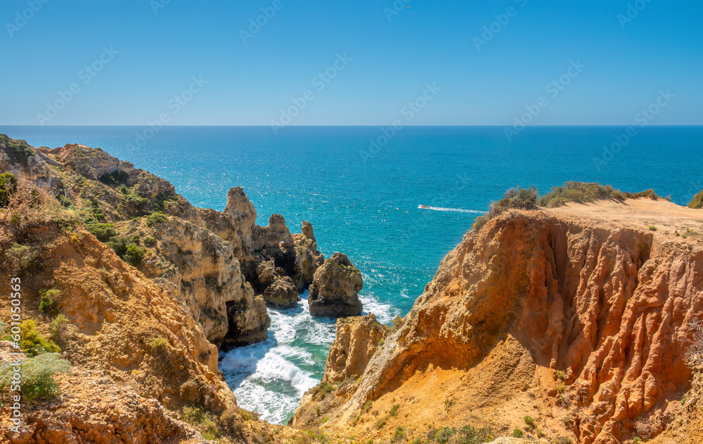 Ponta da Piedade (point of mercy) a headland with dramatic yellow-golden cliff-like rock formations, arches and grottos along the coastline of the town of Lagos, Algarve, Portugal