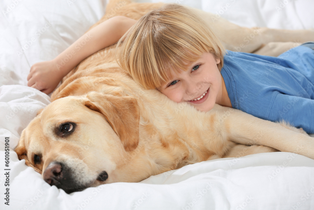 Cute little child with Golden Retriever on bed. Adorable pet Cute little child with Golden Retriever on bed. Adorable pet