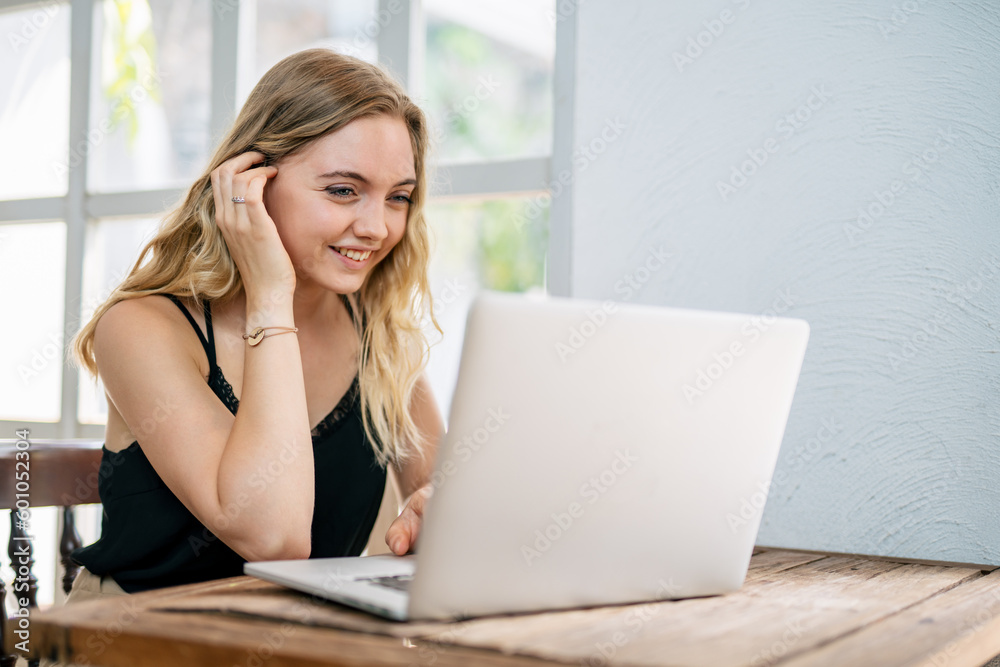 A woman sitting happily shopping online with laptop. Online shopping concept.. A woman sitting happily shopping online with laptop. Online shopping concept..
