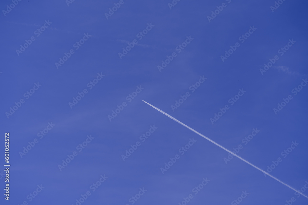 Lonely contrail of jet aircraft in blue sky without clouds, minimalistic natural sky background, aircraft flying high in the sky, cruise missile strikes, azure sky. copy space