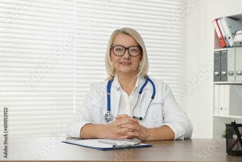 Doctor sitting at wooden table in clinic