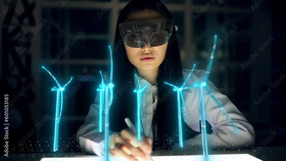 Futuristic Female Engineer Designs in 3D Field with Wind Turbines. Asian Woman Use Augmented Reality Hologram to Work on Green Energy Environmental Power Production