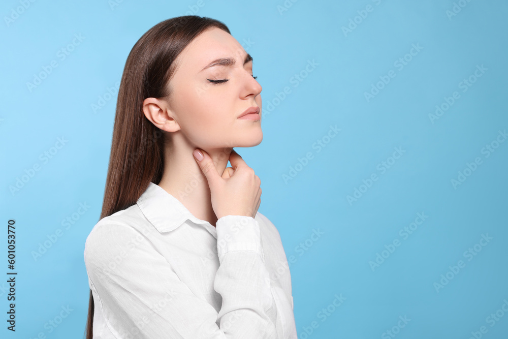 Young woman with sore throat on light blue background. Space for text Young woman with sore throat on light blue background. Space for text