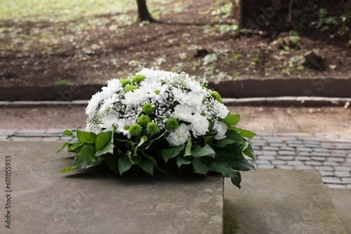 Funeral wreath of flowers on tombstone outdoors