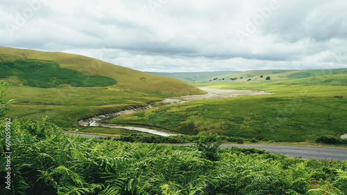 Elan Valley in Wales landscape with river, green field and blue sky