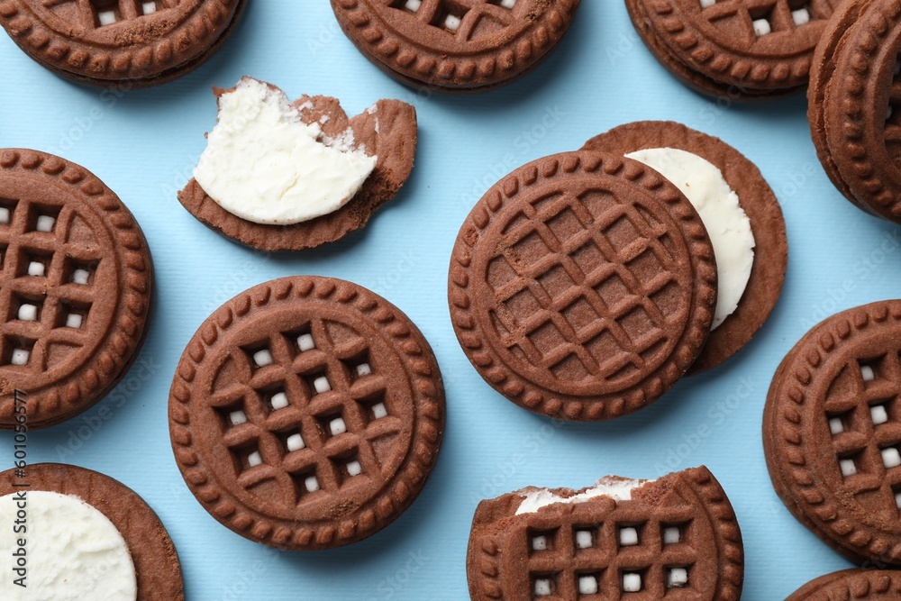 Tasty chocolate sandwich cookies with cream on light blue background, flat lay Tasty chocolate sandwich cookies with cream on light blue background, flat lay