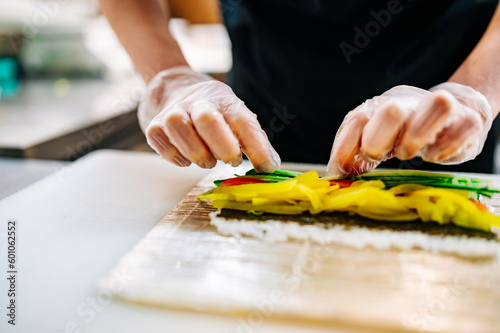 professional chef's hands making sushi roll in a restaurant kitchen