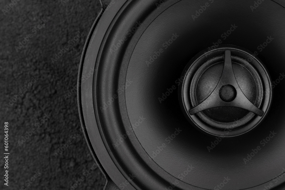 Stylish car audio acoustic round speaker on dark black background, top view. Automobile music, subwoofer, loudspeaker Stylish car audio acoustic round speaker on dark black background, top view. Automobile music, subwoofer, loudspeaker