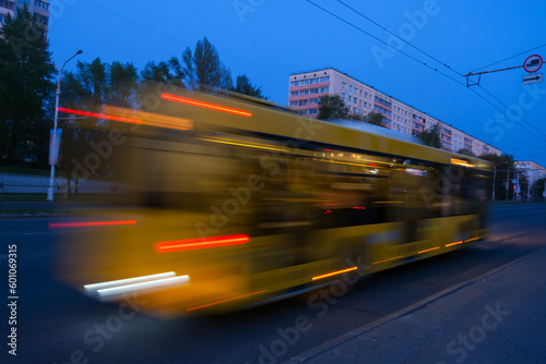 Blurred bus movement down the street in the evening.