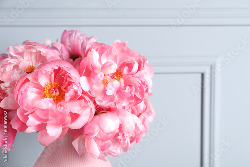 Fototapeta Naklejka Na Ścianę i Meble -  Beautiful bouquet of pink peonies in vase near grey wall, closeup. Space for text