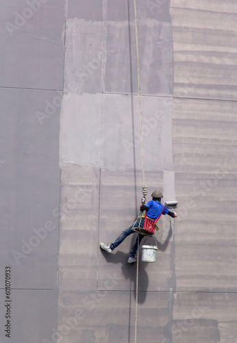 painter hanging on building