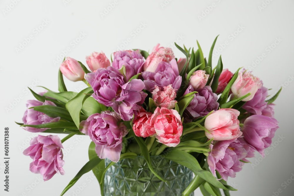 Obraz premium Beautiful bouquet of colorful tulip flowers against white background, closeup