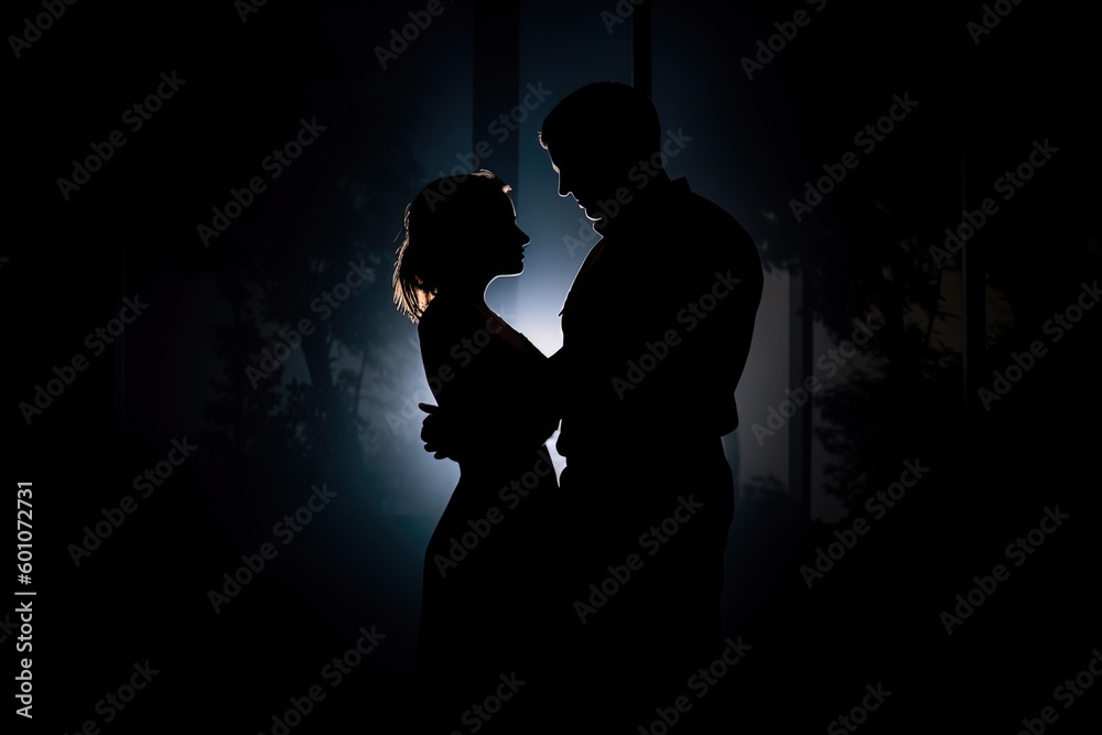 Silhouette of a romantic couple dancing and enjoying in the dark