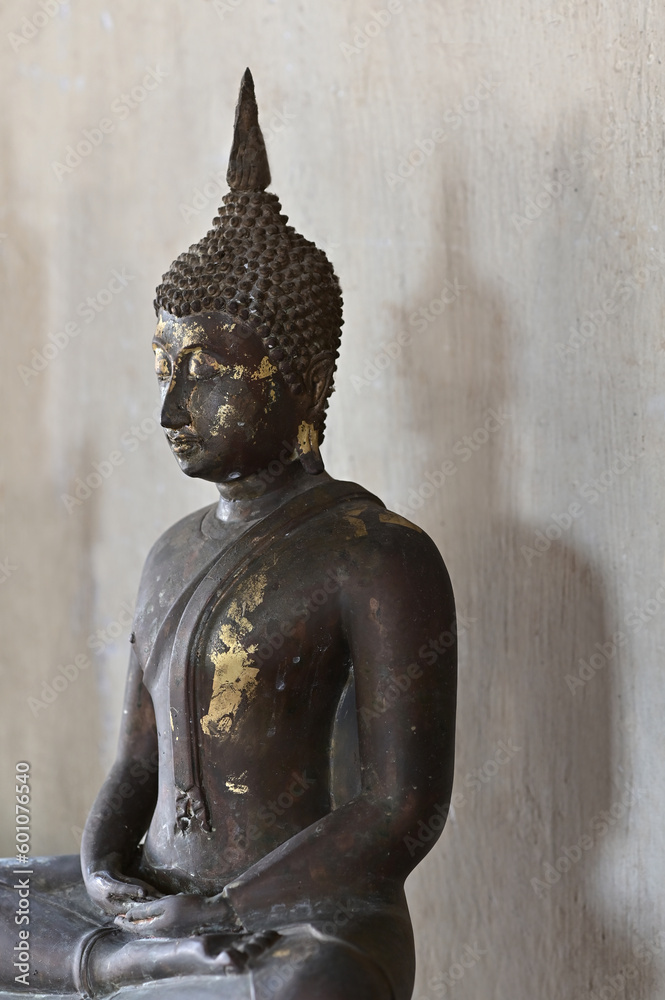 The black steel Buddha image has a shadow behind it in the temple. The black steel Buddha image has a shadow behind it in the temple.