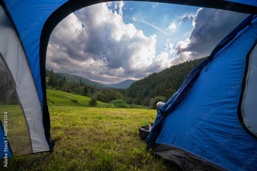 View from inside the tourist tent. Beautiful mountains, pine forest an clouds. Copy space. Vacation and hobbie. Carpathian Mountains. Summer day Ukraine