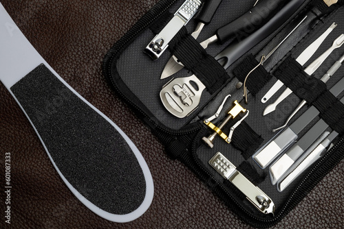 Professional Manicure Tools and Equipments Set in the Bag on Brown Leather Background.