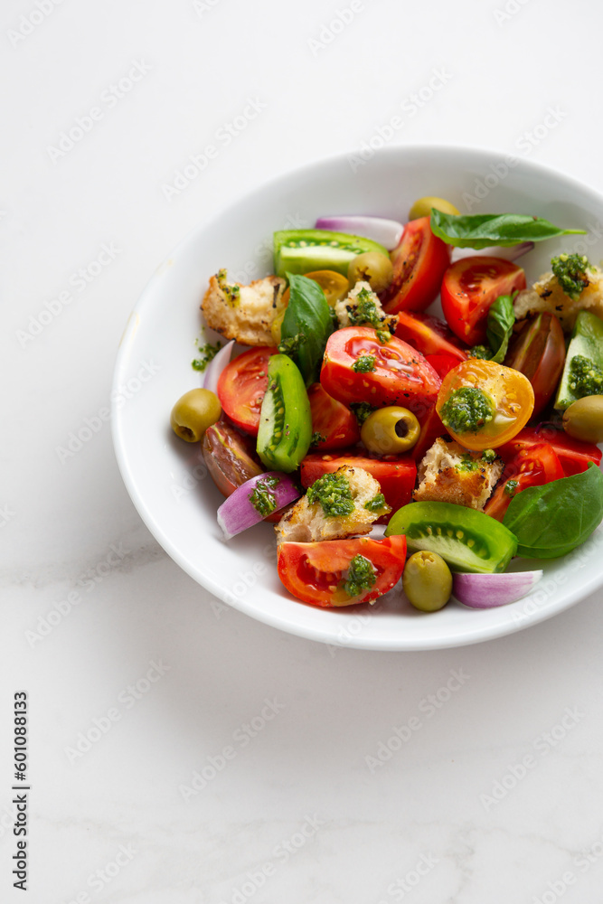 Close up of summer tomato salad with green pesto
