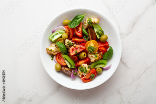 Overhead view of summer tomato salad with pesto