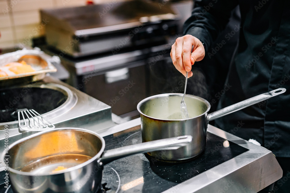 Chef hands cooking cheese sauce in the restaurant kitchen Chef hands cooking cheese sauce in the restaurant kitchen