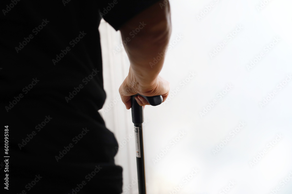 Close up photo of elderly man's hand with walking stick with copyspace