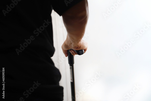 Close up photo of elderly man s hand with walking stick with copyspace