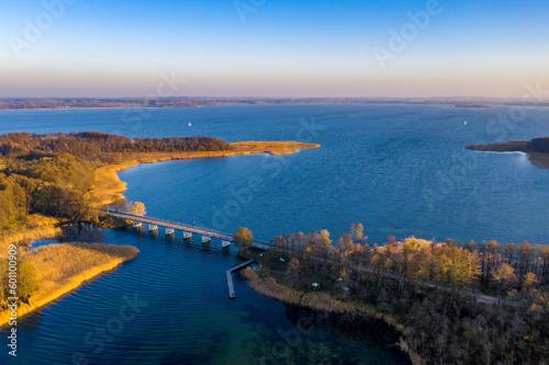 Masurian Lake District in Poland - bridge over lake, beautifiul drone landscape, blue water, forest, autumn sunset time, Mazury great lakes