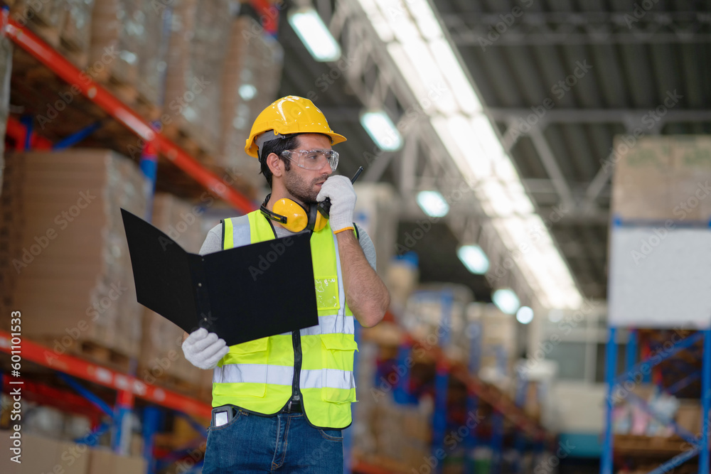A male manager is checking inventory inside a warehouse.