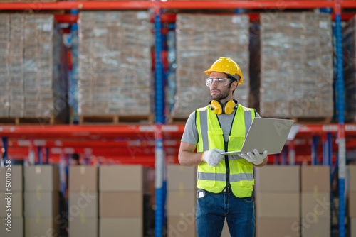 A male manager is checking inventory inside a warehouse.