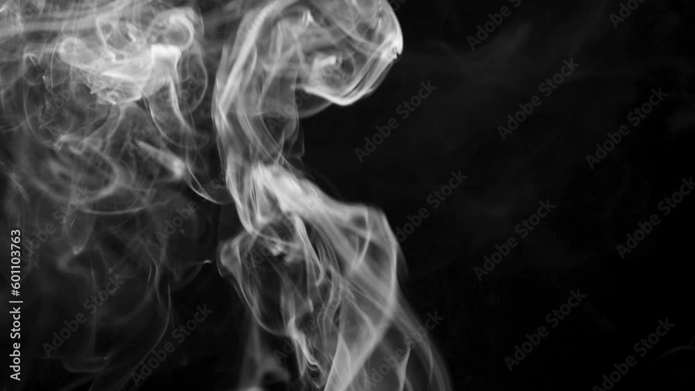 Abstract smoke or steam is rising and floating in the air on a black background. Abstract smoke or steam is rising and floating in the air on a black background.