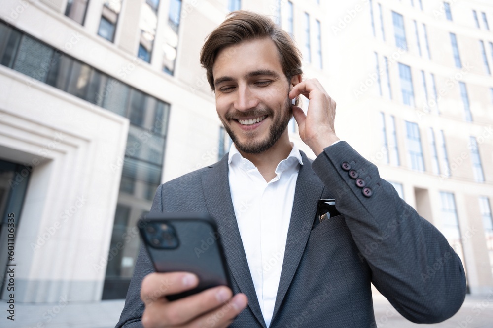 Confident young businessman using cell phone in the city. Confident young businessman using cell phone in the city.