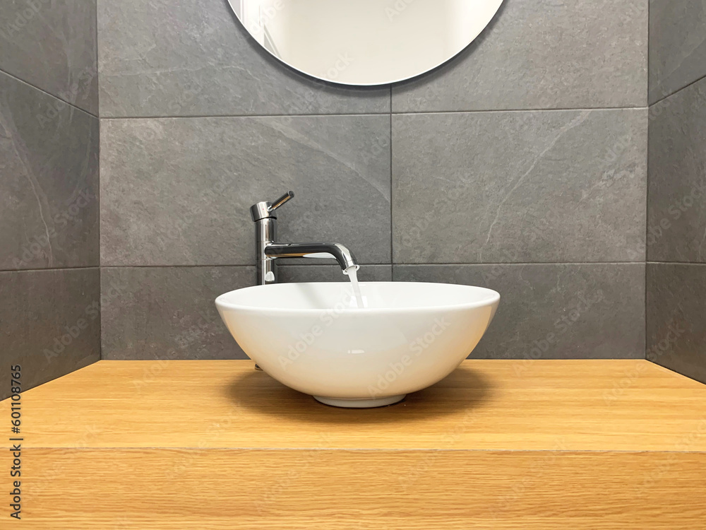 Fototapeta premium chromed taps in black and white modern minimal bathroom with wood plan. Open water flow