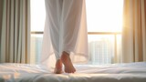 Close-up of an Asian girl stepping down from a bed in white pajamas