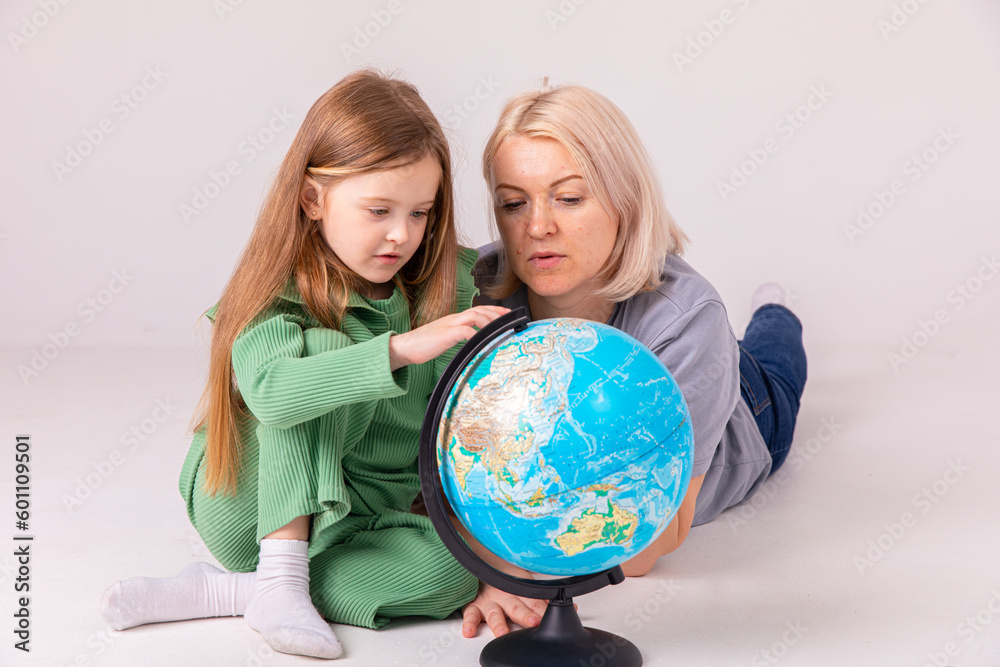 Go on an adventure. Happy family preparing for the journey. Mom and daughter study the map and choose a route of travel. Go on an adventure. Happy family preparing for the journey. Mom and daughter study the map and choose a route of travel.