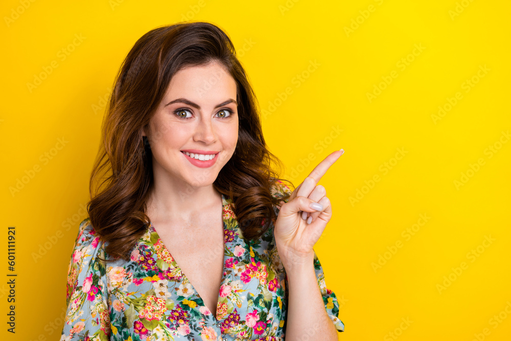 Portrait of cute cheerful girl toothy smile indicate finger empty space proposition isolated on yellow color background Portrait of cute cheerful girl toothy smile indicate finger empty space proposition isolated on yellow color background