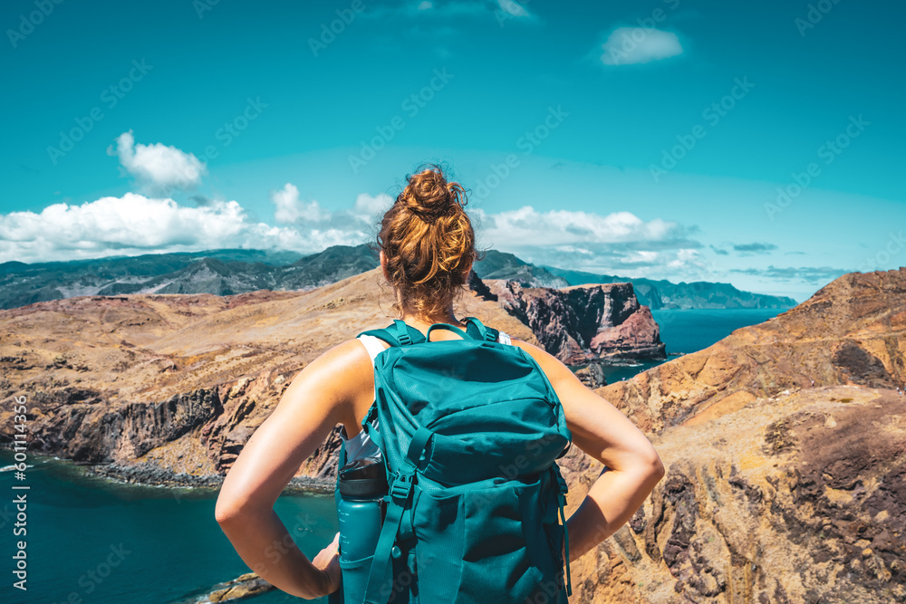 Athletic woman enjoys the view on the Madeiran island from hiking trail. São Lourenço, Madeira Island, Portugal, Europe. - obrazy, fototapety, plakaty 