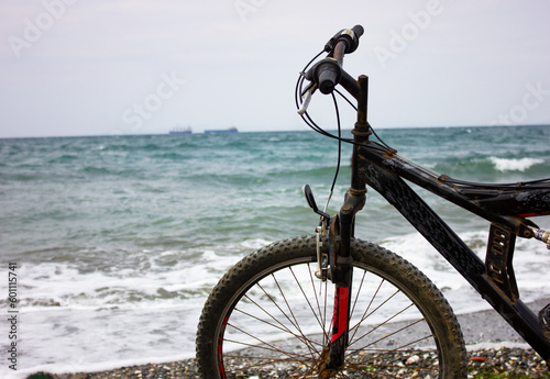 Mountain bike on the beach and wavy sea view on background. Conceptual bicycle and sea image with copy space. Bike on beach sands.