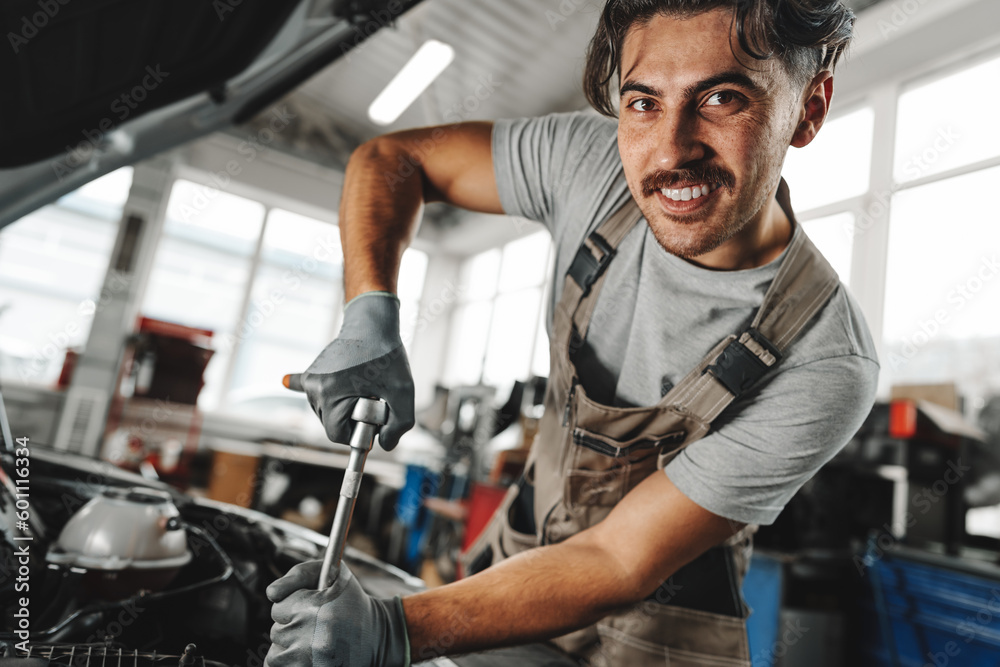 Mechanic examining car in auto car repair service center Mechanic examining car in auto car repair service center